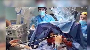 Imagen de la mujer tocando el violín mientras es operada