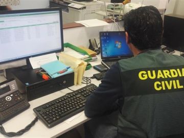 Imagen de archivo de un guardia civil consultando dos ordenadores