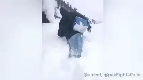 Un hombre se abre paso por la nieve para llevar vacunas a niños en Pakistán Un hombre se abre paso por la nieve para llevar vacunas a niños en Pakistán