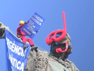 Dos activistas de Greenpeace colocan unas gafas de buzo a la estatua de Colón en Barcelona