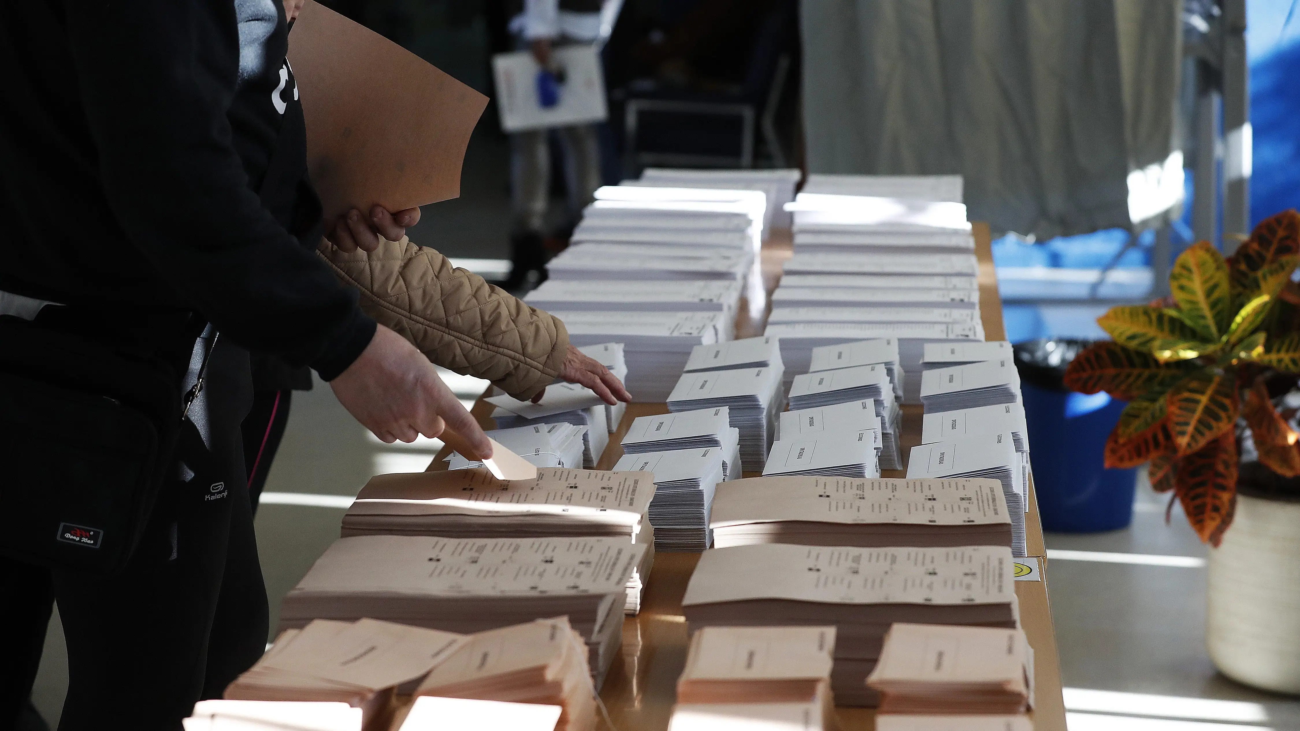 Imagen de una mesa con las papeletas electorales en uno de los colegios
