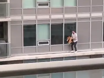 Un hombre se juega la vida caminando por una cornisa para rescatar a su gato de un balcón vecino Un hombre se juega la vida caminando por una cornisa para rescatar a su gato de un balcón vecino