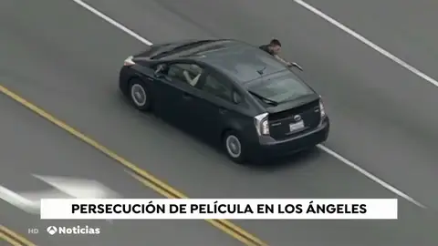 Un helicóptero graba como un hombre saca medio cuerpo por la ventanilla de su coche para disparar a la policía mientras huía Un helicóptero graba como un hombre saca medio cuerpo por la ventanilla de su coche para disparar a la policía mientras huía