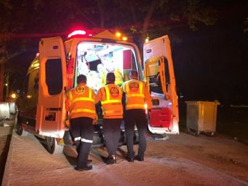 Una ambulancia con efectivos atendiendo al joven herido en una reyerta en Madrid