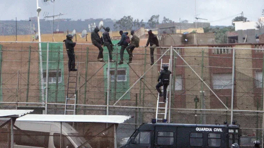 Imagen de archivo de migrantes subidos a la valla de Melilla Imagen de archivo de migrantes subidos a la valla de Melilla
