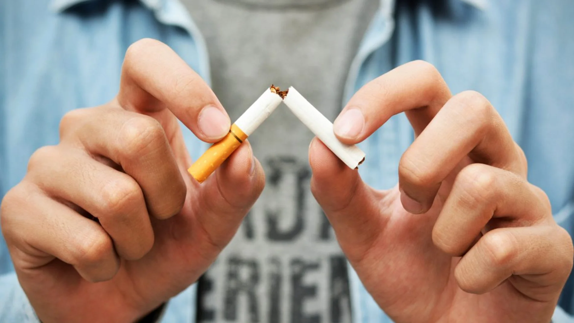 Imagen de archivo de un joven rompiendo un cigarro. Imagen de archivo de un joven rompiendo un cigarro.