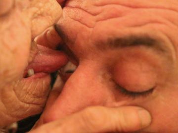 Anciana limpia ojos con la lengua Anciana limpia ojos con la lengua