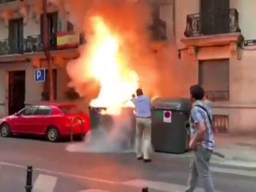 Javier Ortega Smith apaga un contenedor en llamas frente a la sede de Vox en Madrid