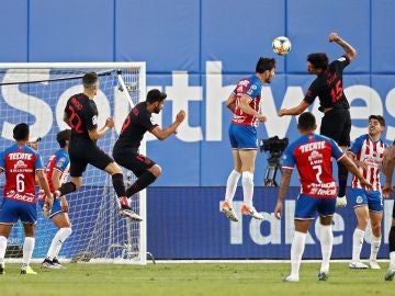 Jugadores del atleti y de las chivas disputan un balón aéreo