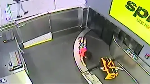 Un niño en una cinta transportadora de maletas Un niño en una cinta transportadora de maletas