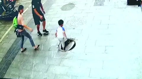 Un niño cae por una alcantarilla y su padre consigue rescatarlo en China Un niño cae por una alcantarilla y su padre consigue rescatarlo en China