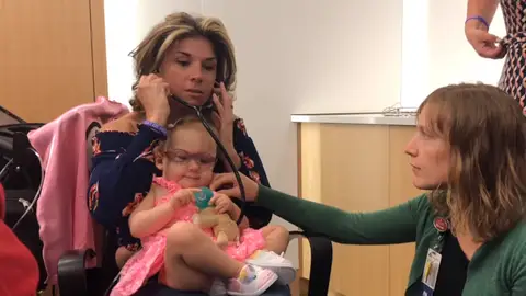 La madre escuchando los latidos de la niña La madre escuchando los latidos de la niña