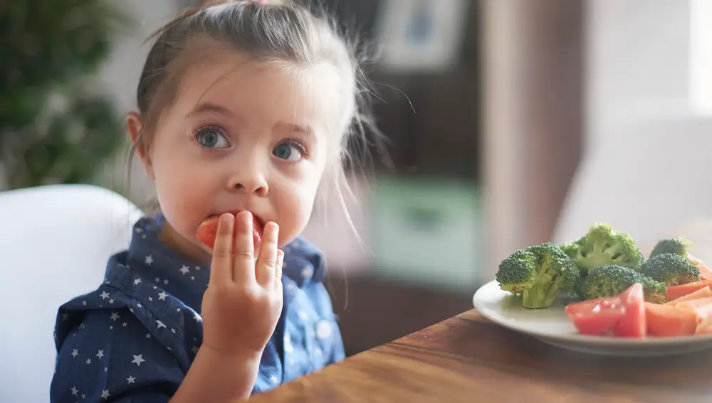 Niña comiendo verdura Niña comiendo verdura