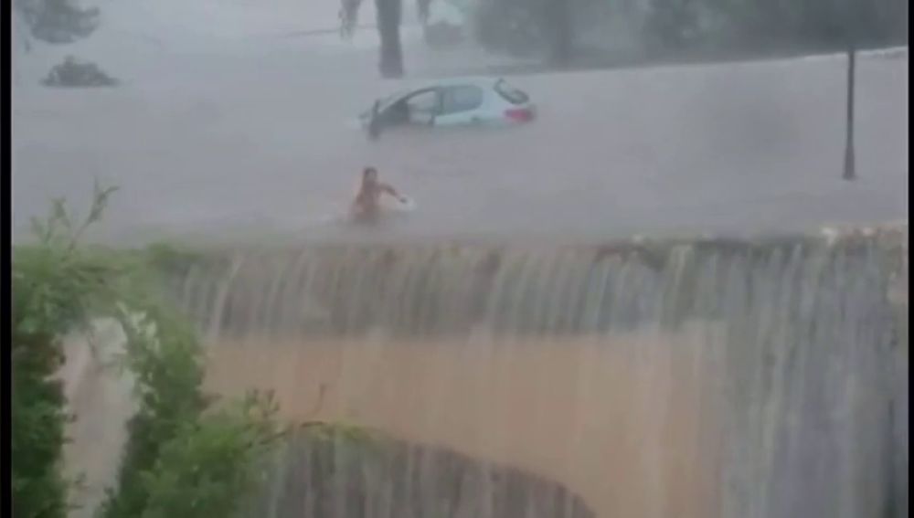 Una mujer sale nadando de su coche en una gran inundación en Mallorca