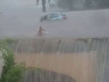 Una mujer sale nadando de su coche en una gran inundación en Mallorca