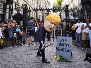 Un hombre vestido con una careta del primer ministro del Reino Unido, Boris Johnson, participa en una protesta frente al número 10 de Downing Street en Londres.