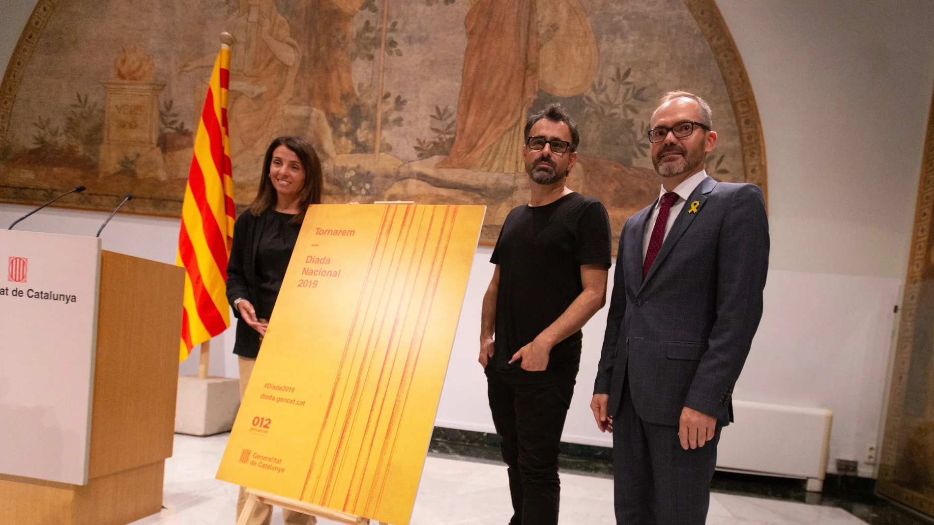 La consellera de Presidencia, Meritxell Budó, y el vicepresidente del Parlament, Josep Costa, acompañados del creador artístico del cartel del acto oficial de la Diada. La consellera de Presidencia, Meritxell Budó, y el vicepresidente del Parlament, Josep Costa, acompañados del creador artístico del cartel del acto oficial de la Diada.