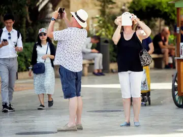 Varios turistas toman fotografías con sus teléfonos Varios turistas toman fotografías con sus teléfonos