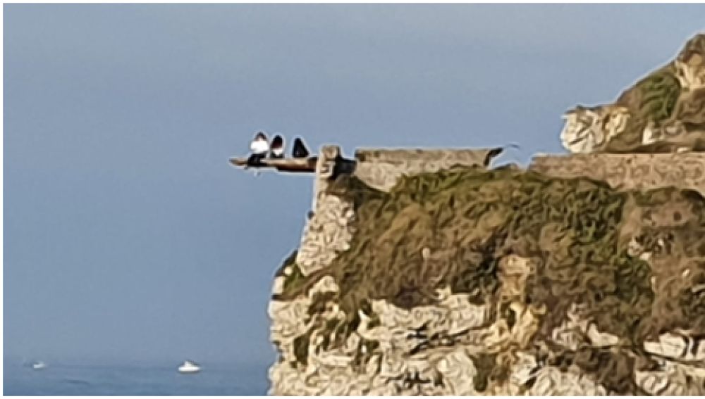Tres jóvenes haciéndose 'selfies' en el borde de un acantilado