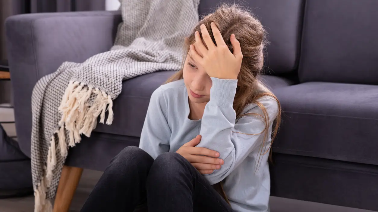 Niña con dolor de cabeza Niña con dolor de cabeza