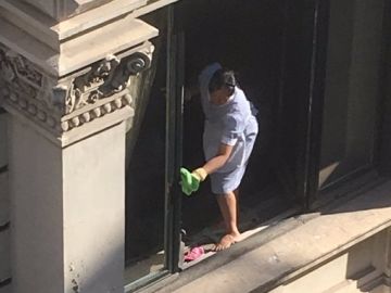 La limpiadora sacando brillo a la ventana