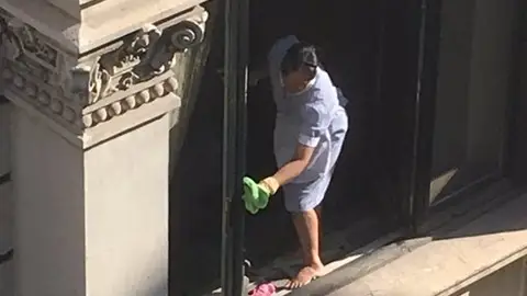 La limpiadora sacando brillo a la ventana La limpiadora sacando brillo a la ventana