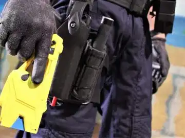 Policía con pistola taser Policía con pistola taser