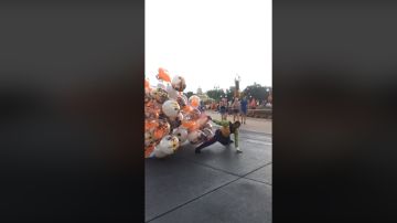 Un vendedor de globos en Disney World sale casi volando por el viento