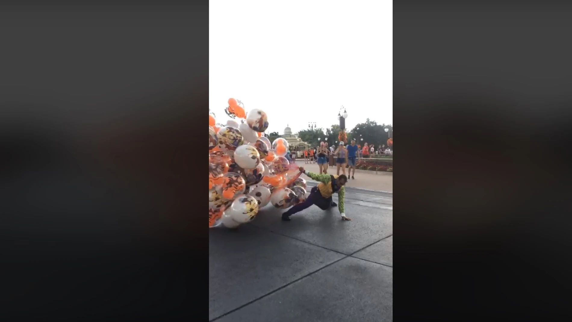 Un vendedor de globos en Disney World sale casi volando por el viento Un vendedor de globos en Disney World sale casi volando por el viento