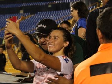 Un aficionado toca un pecho a una jugadora mientras se sacan una foto