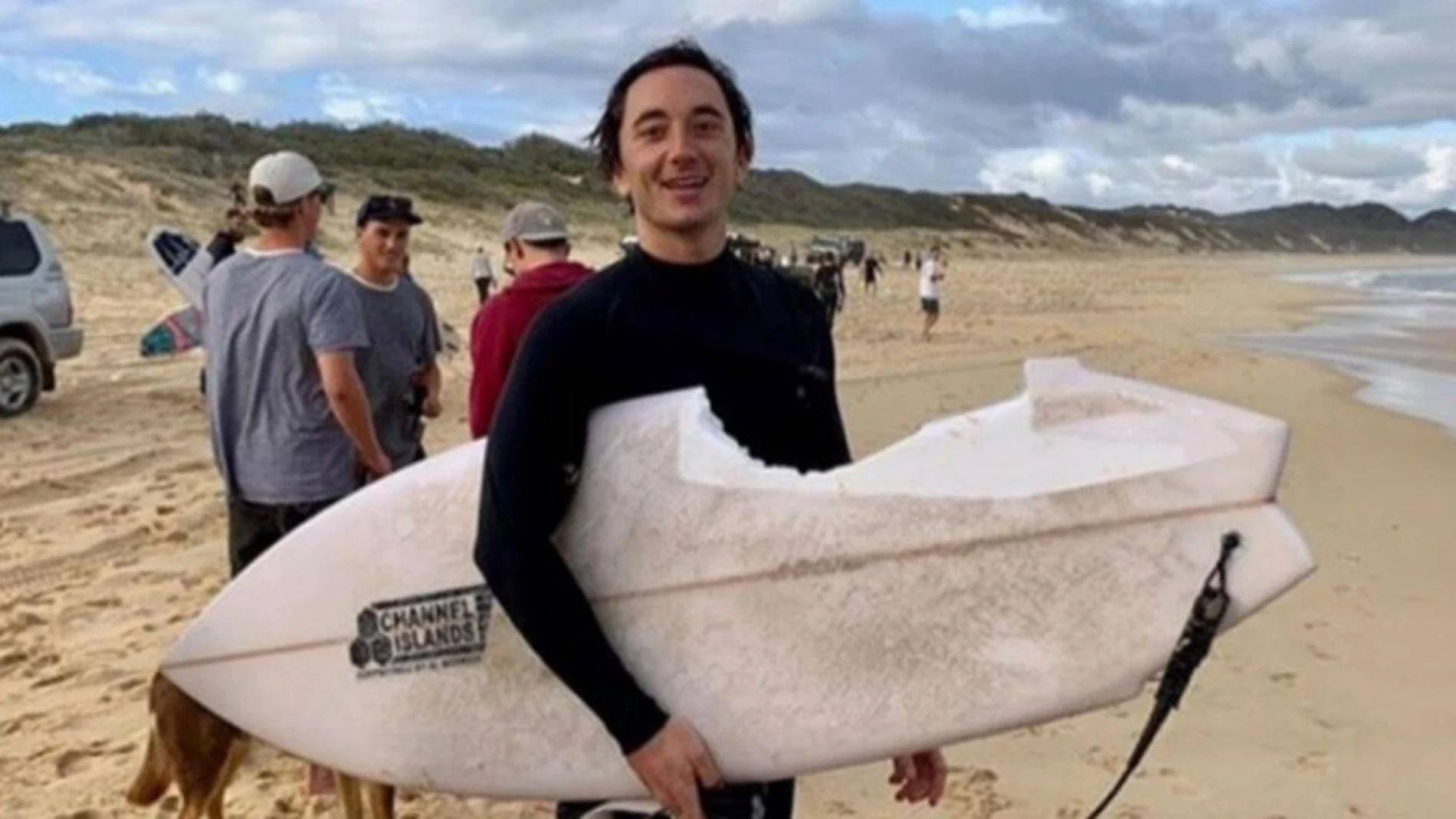 Mike Bruton posa con su tabla de surf tras el ataque del tiburón Mike Bruton posa con su tabla de surf tras el ataque del tiburón