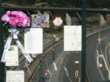 Diversos objetos en recuerdo y homenaje de las víctimas cuelgan de la valla en el paso elevado sobre la curva de A Grandeira Diversos objetos en recuerdo y homenaje de las víctimas cuelgan de la valla en el paso elevado sobre la curva de A Grandeira
