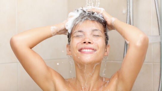 Mujer frotándose el pelo en la ducha