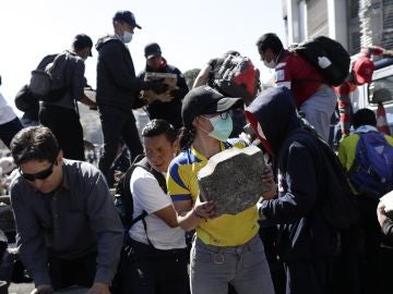 Un grupo de personas usa mascarillas sanitarias en las labores de limpieza 