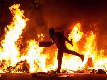 Un manifestante echa al fuego un cartón junto a la Delegación del Gobierno en Barcelona Un manifestante echa al fuego un cartón junto a la Delegación del Gobierno en Barcelona