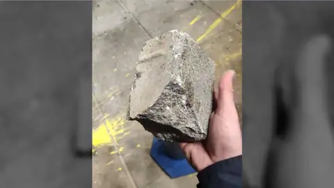 Adoquín lanzado a la policía Adoquín lanzado a la policía