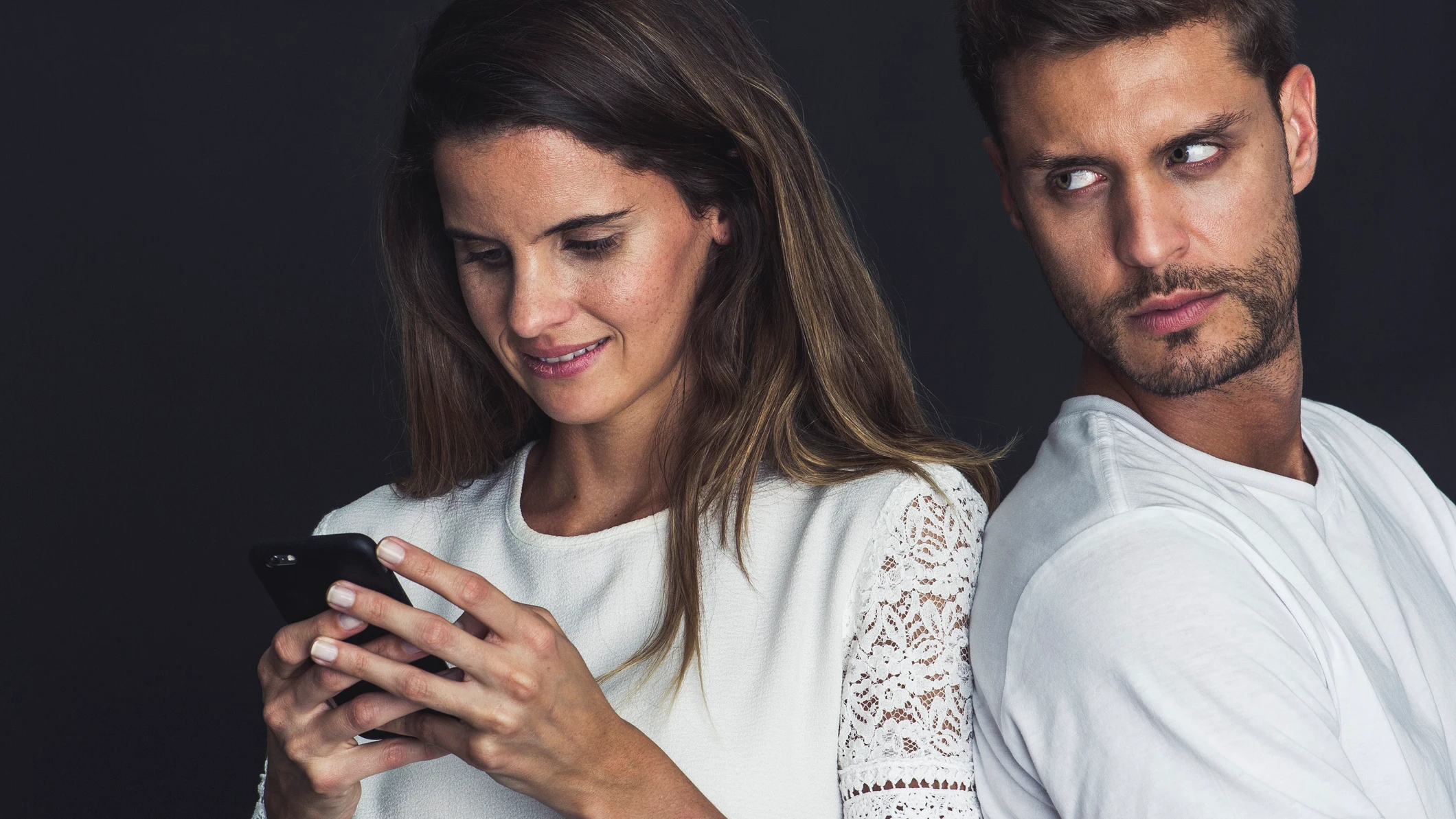 Pareja celosa, mirando de reojo el m&oacute;vil.