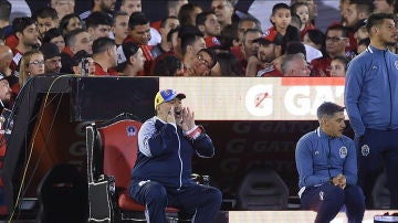 Maradona da instrucciones sentado en su trono