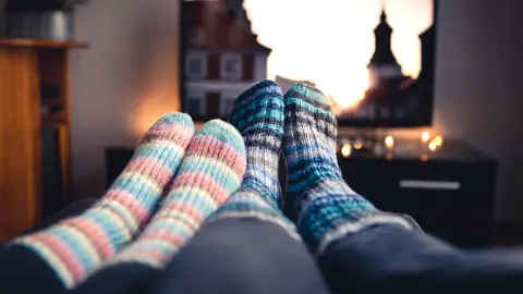 Pareja viendo la tele con calcetines gruesos Pareja viendo la tele con calcetines gruesos