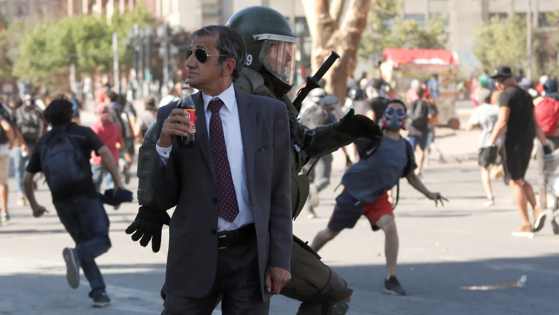 Hombre tomando un refresco en una protesta en Chile Hombre tomando un refresco en una protesta en Chile