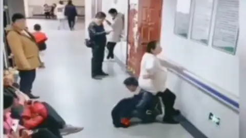 Un hombre hace de 'silla' a su mujer embarazada al ver que nadie le cede su asiento en un hospital de China Un hombre hace de 'silla' a su mujer embarazada al ver que nadie le cede su asiento en un hospital de China