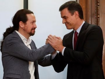 Pablo Iglesias y Pedro Sánchez se estrechan la mano sonrientes