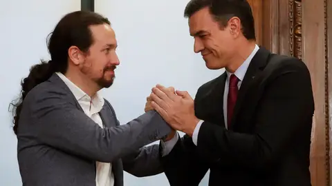 Pablo Iglesias y Pedro Sánchez se estrechan la mano sonrientes Pablo Iglesias y Pedro Sánchez se estrechan la mano sonrientes