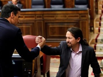 El líder de Unidas Podemos, Pablo Iglesias, saluda a Pedro Sánchez