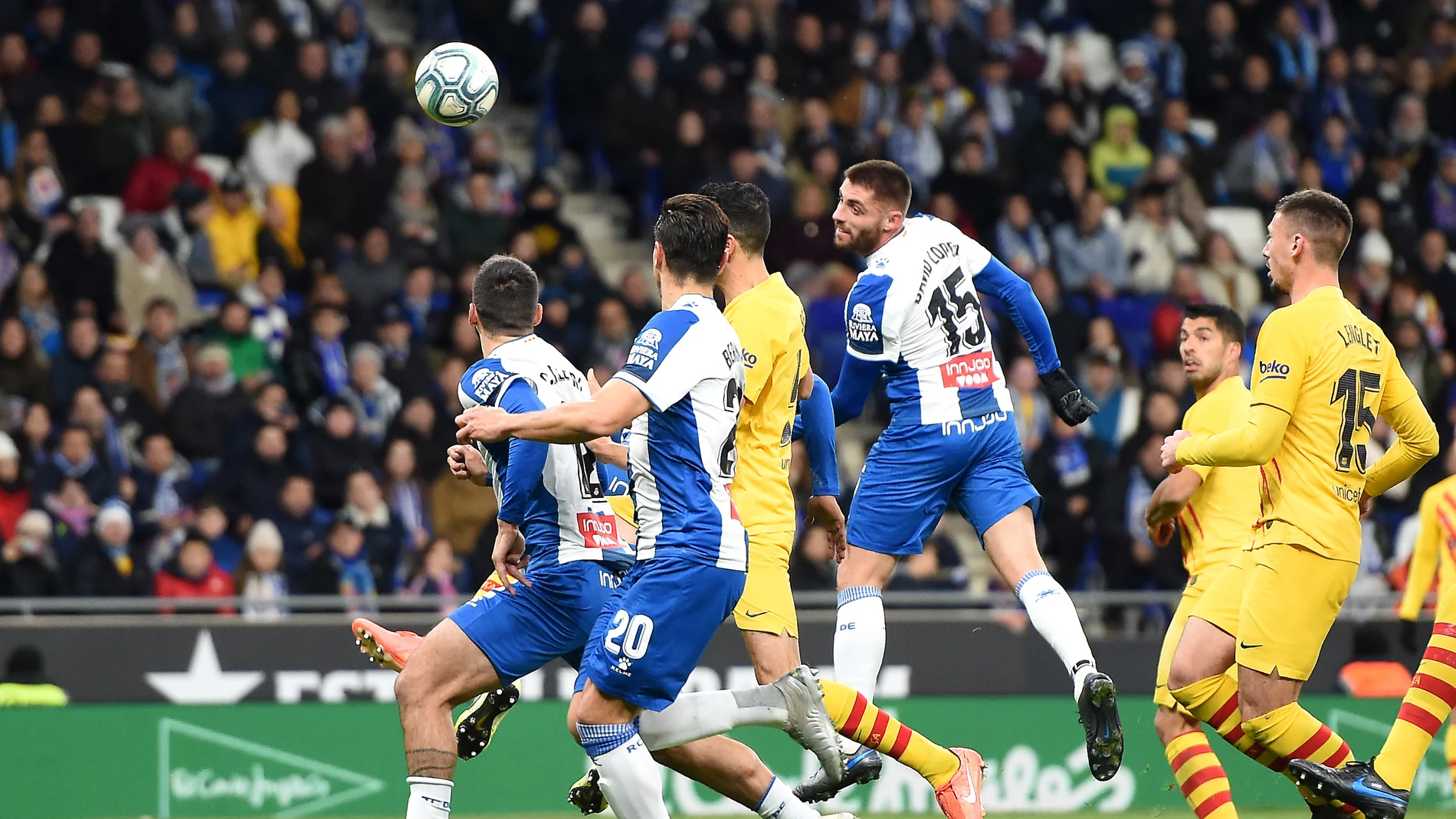 Los jugadores de Espanyol y Barça disputan un balón aéreo Los jugadores de Espanyol y Barça disputan un balón aéreo