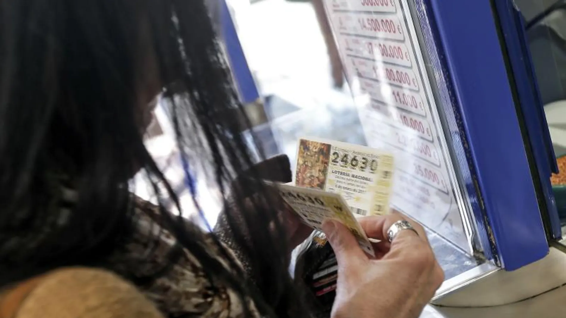 Una mujer compra varios décimos en una administración de Lotería Una mujer compra varios décimos en una administración de Lotería
