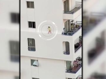 Una niña corretea peligrosamente por la cornisa de un edificio de apartamentos en Adeje