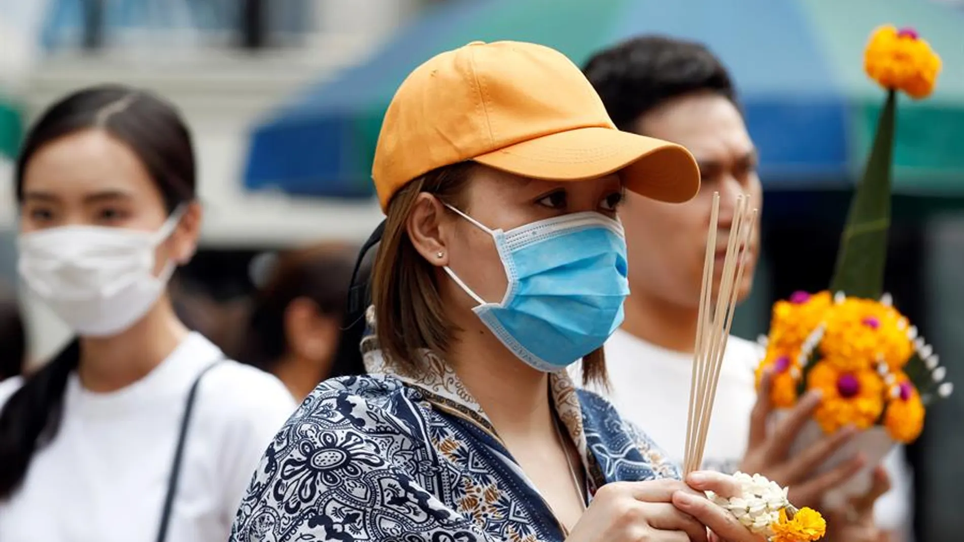 Una mujer se protege con una mascarilla Una mujer se protege con una mascarilla