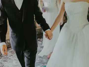 Unos novios cogidos de la mano en su boda Unos novios cogidos de la mano en su boda