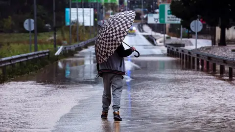Imagen de archivo Un hombre se resguarda de la lluvia con un paraguas